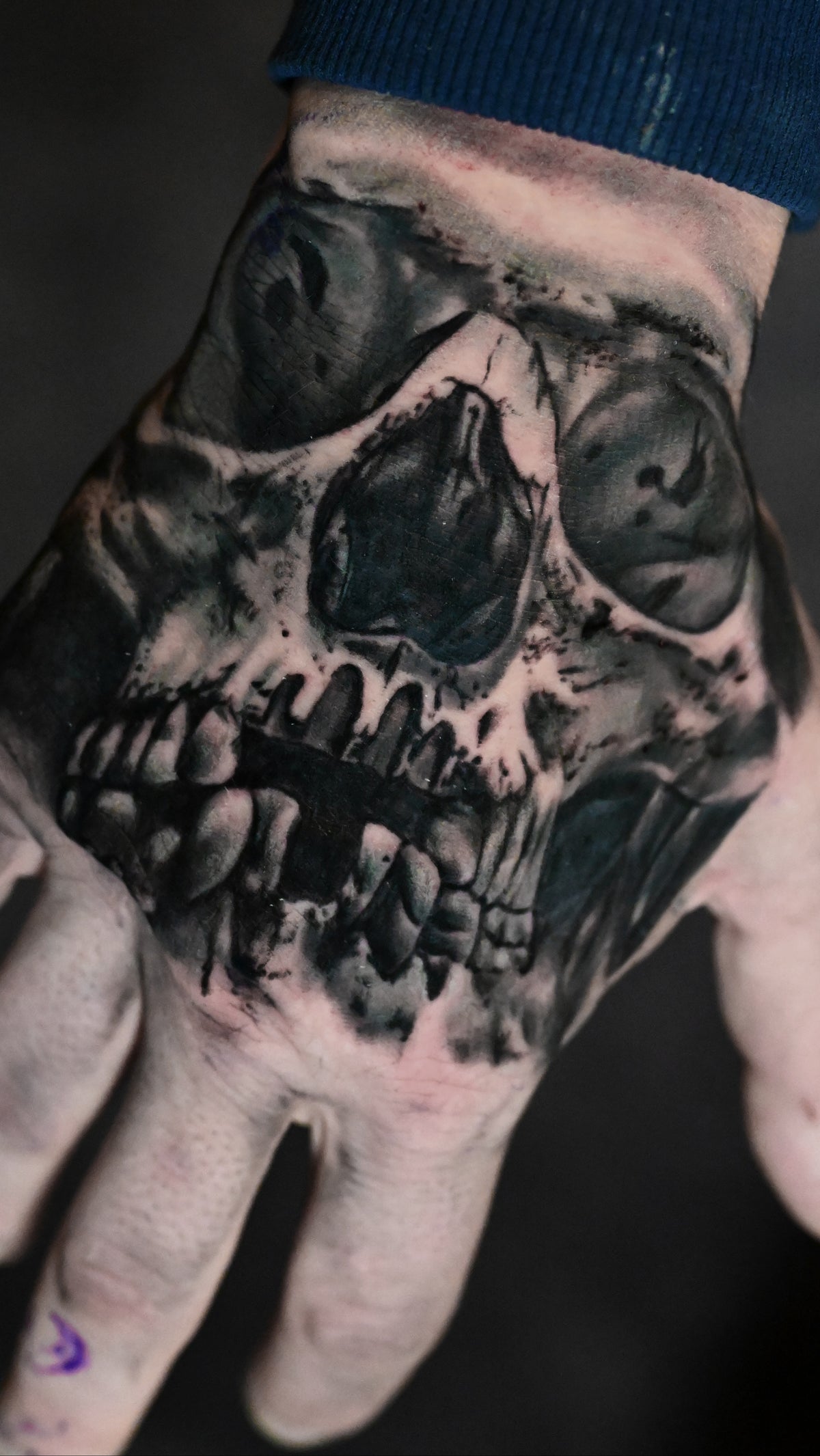 Dark realistic skull tattoo on hand